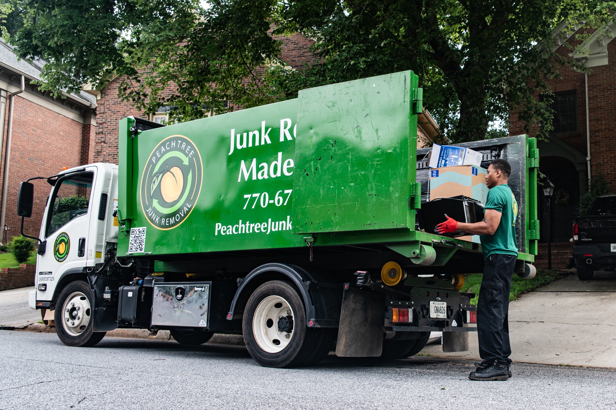 A Peachtree Junk Removal crew member loading a full truck on an Atlanta job
