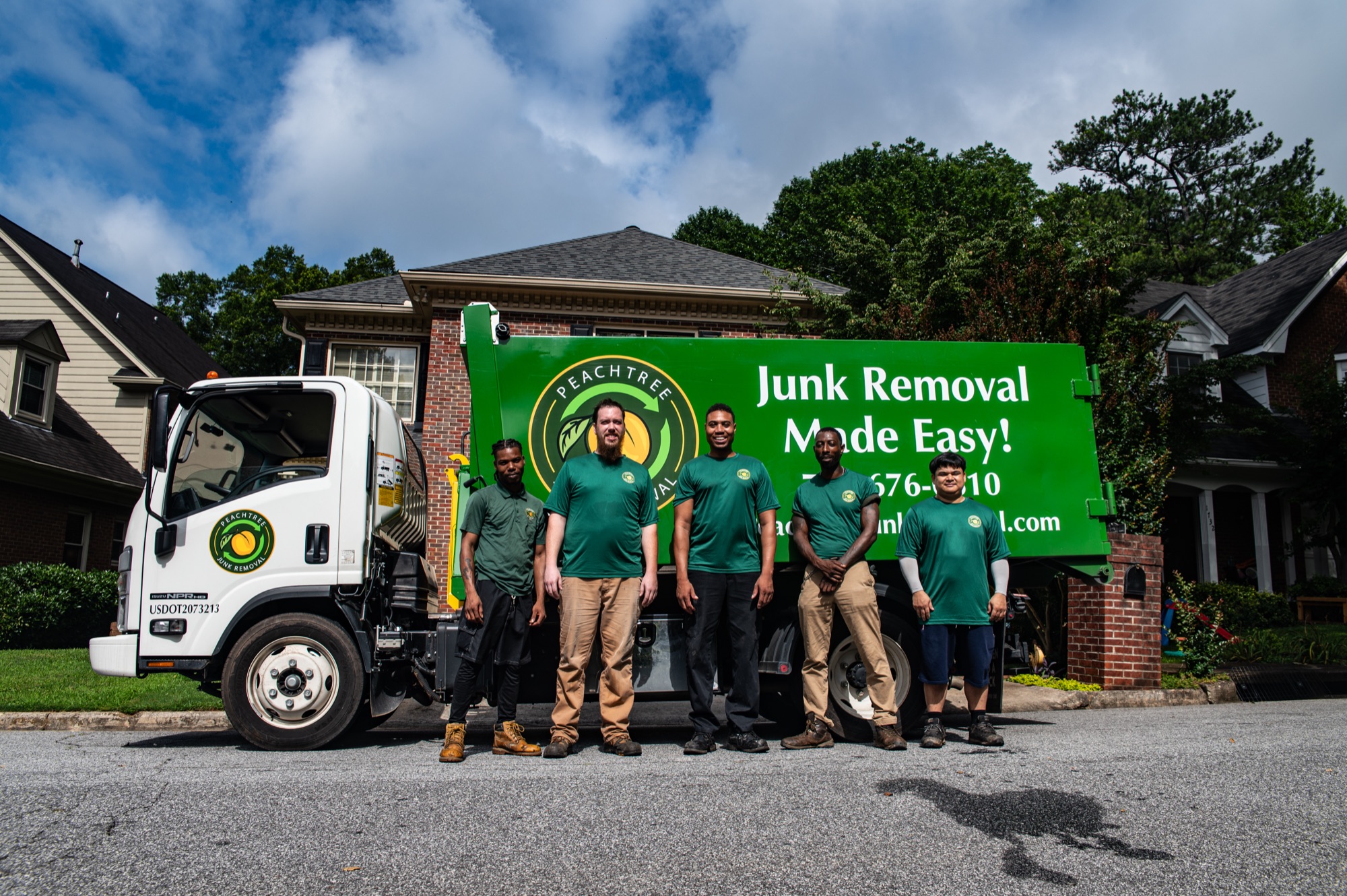 The full Peachtree Junk Removal crew lined up at their truck