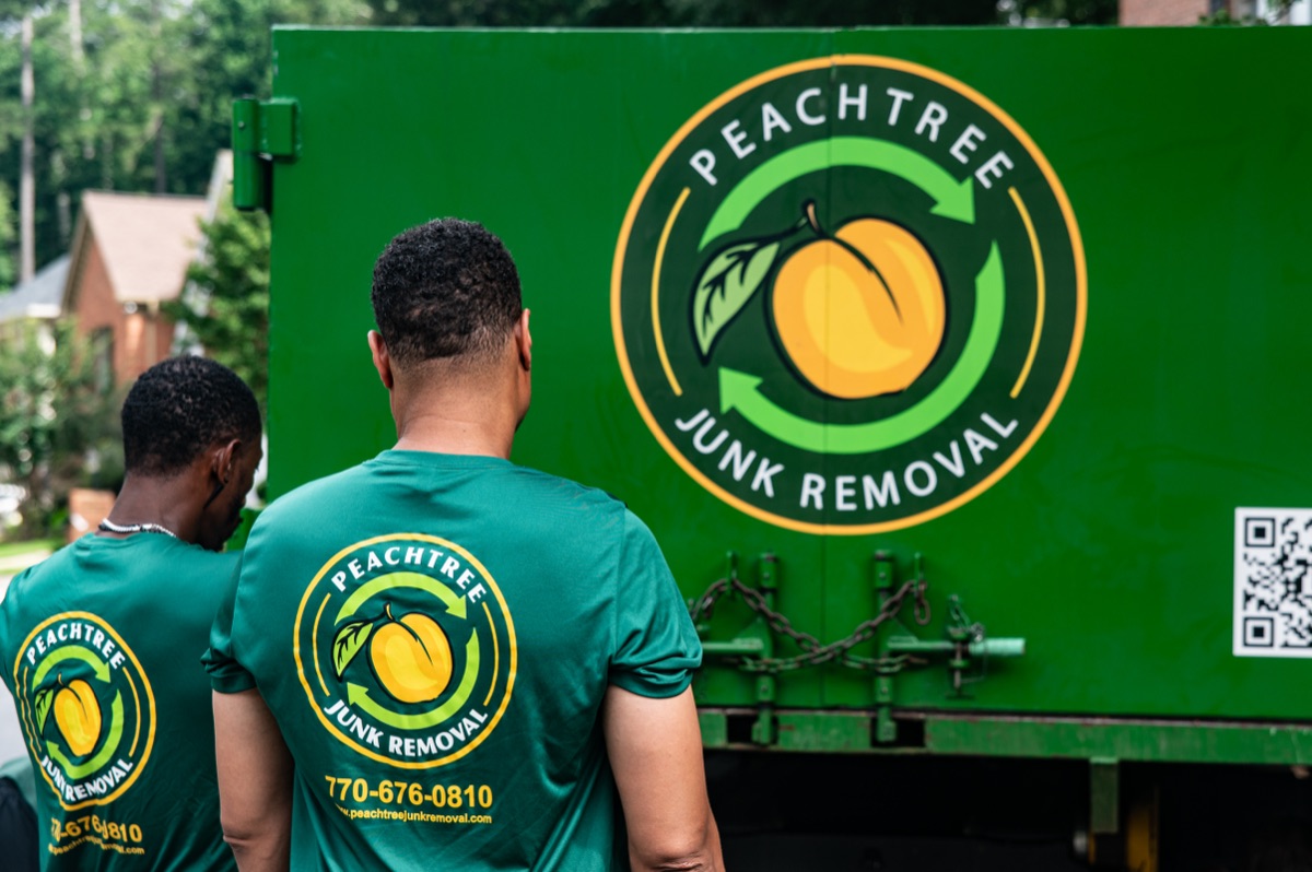 Two uniformed Peachtree crew members at the truck's logo door