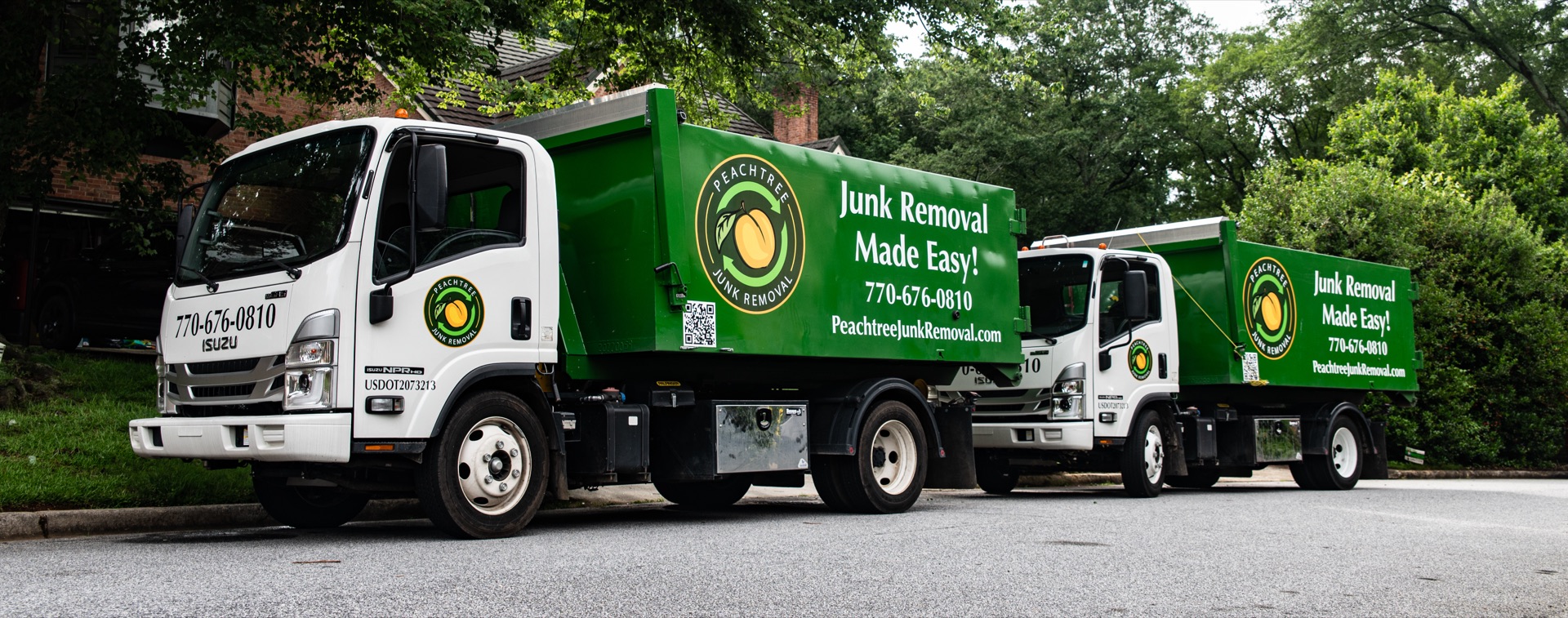 Two Peachtree Junk Removal trucks on an Atlanta job